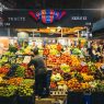 Colorful market stall displaying fresh fruits and vegetables in Barcelona's bustling market.